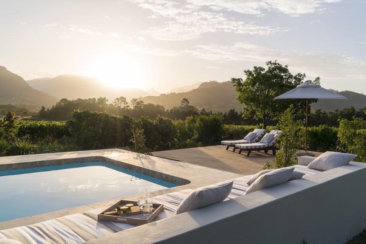 Cape Vue Country House, Franschhoek: the pool and terrace looking out over the vineyards to the mountains